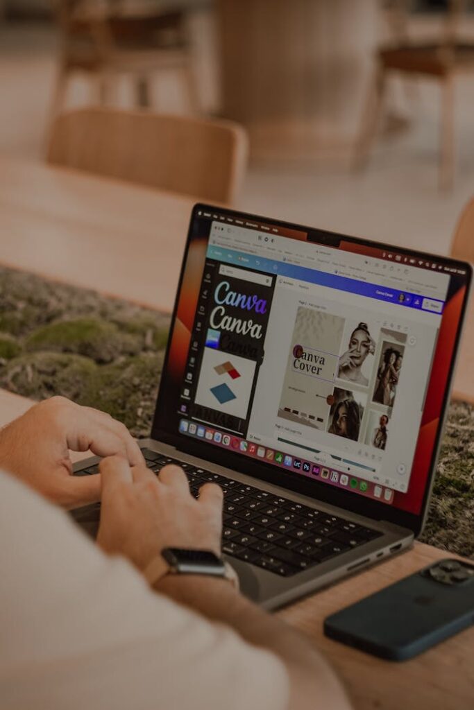 Close-up of a person using a laptop to design with Canva.
